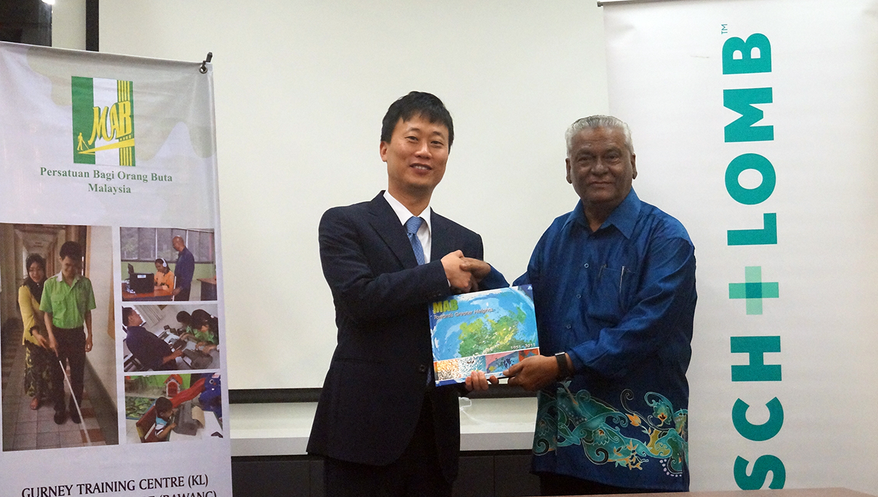 Dr. S. Radha Krishnan (right) gives the souvenir to Mr. Jake Kim