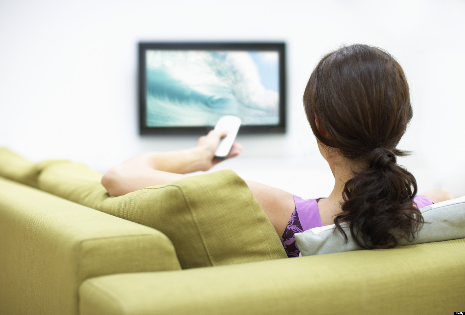 Young woman watching television, rear view