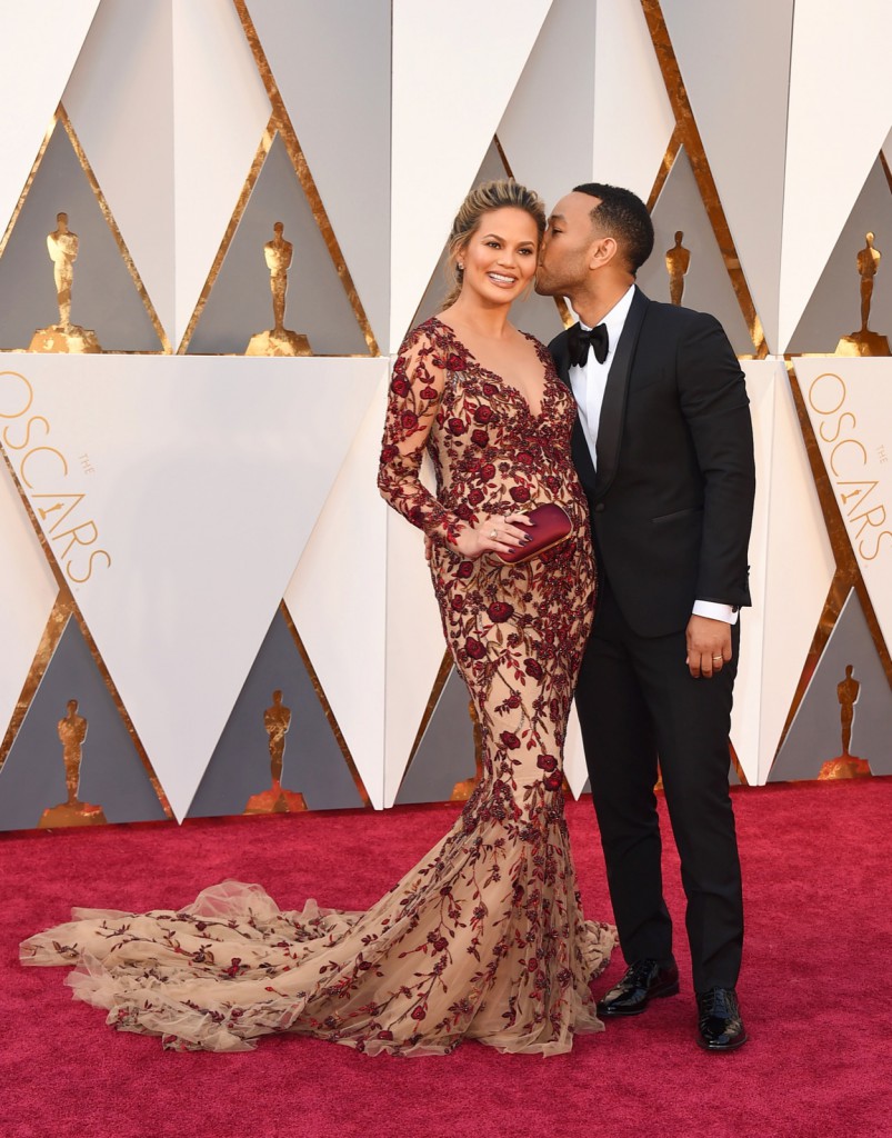 Chrissy Teigen, left, and John Legend arrive at the Oscars on Sunday, Feb. 28, 2016, at the Dolby Theatre in Los Angeles. (Photo by Jordan Strauss/Invision/AP)