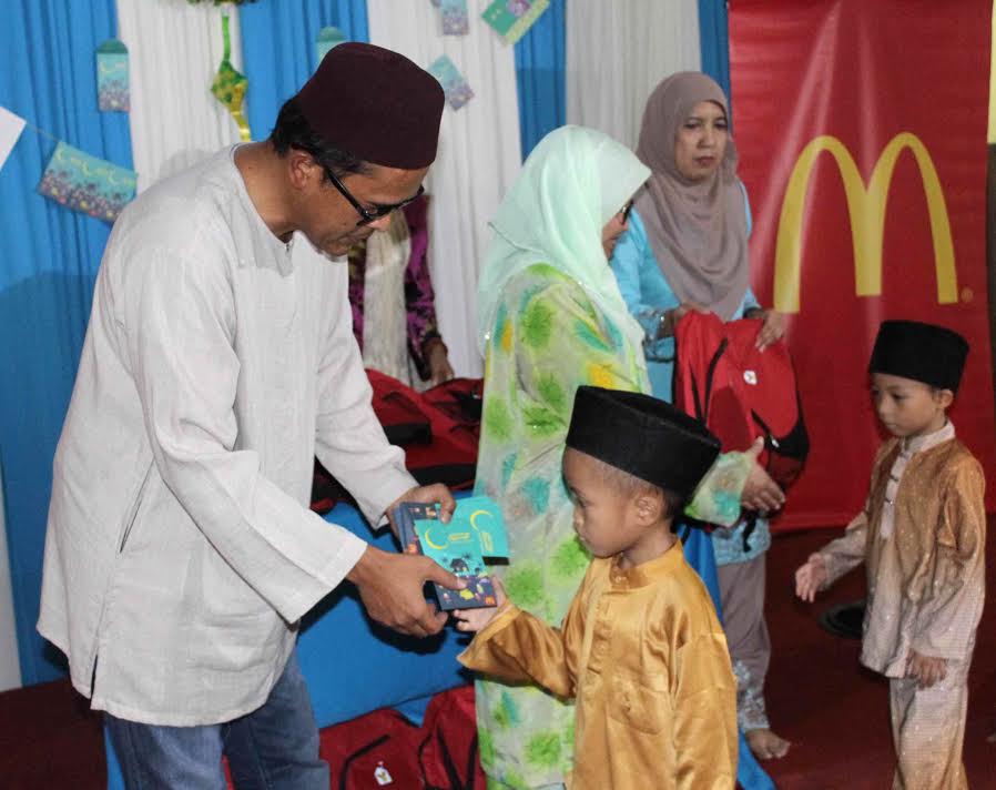 Azmir Jaafar, Managing Director of McDonald’s Malaysia distributing duit raya and school necessities to children from Pusat Jagaan Lambaian Kasih.