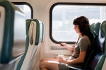 Young woman sitting in a train text messaging
