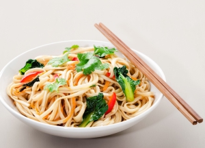 Chinese asian noodles stir fry with vegetables served with a pair of chopsticks
