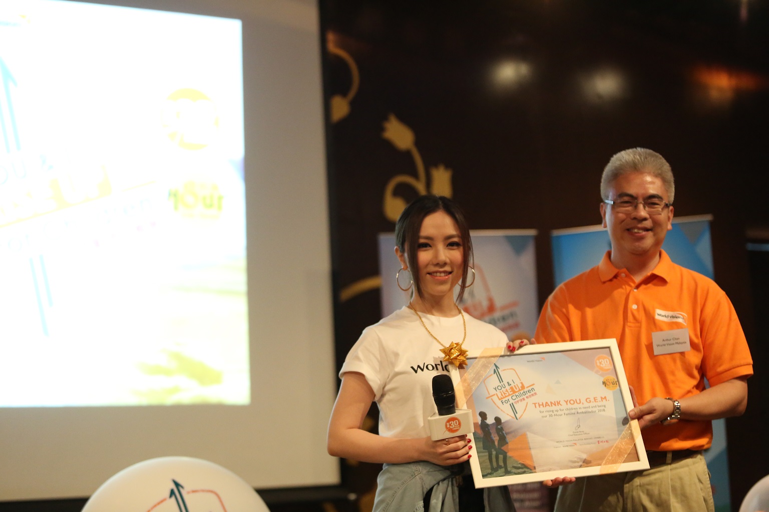 World Vision’s 30-Hour Famine 2018 Ambassador G.E.M. (left) received a token of appreciation from World Vision Malaysia’s Head of Public Engagement Arthur Chan