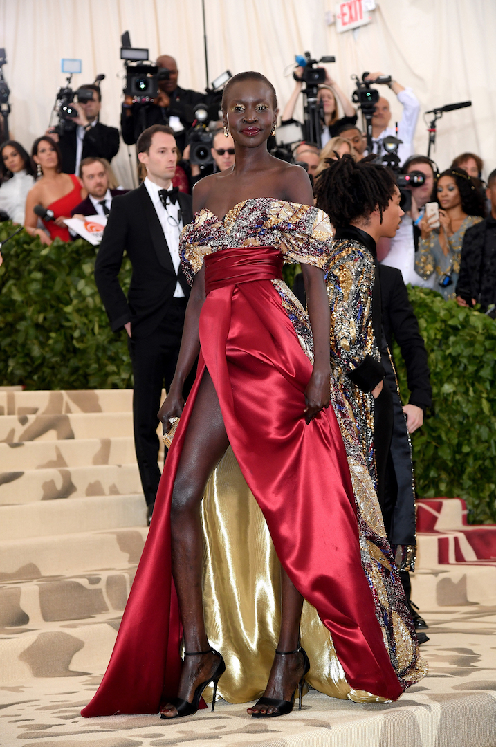 Model and activist Alek Wek wore a draped, flowing gown that took inspiration from mosaics. A long train of silver and jewel tones was created from a pattern of beading and sequins. The mosaic-like pattern also appeared at the off-the-shoulder bust, which was contrasted with a waist and skirt in deep red double silk, lined in gold and slit high at the front. (Photo by Karwai Tang/Karwai Tang/Getty Images)